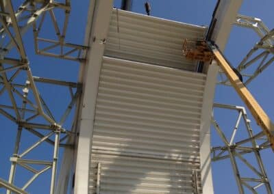 The crane operator and workers collaborate to carefully align a segment of the main shutter onto the arch girder main tracks. 29 August 2013