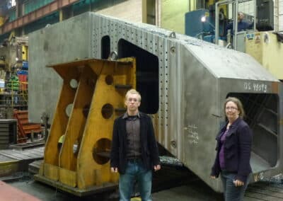 James Linden and LeEllen Phelps in front of a sector of the enclosure base ring (1 of 14 total sectors) as it undergoes machining, November 2012.