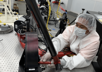 Technician places an optical element in the light path of a lens.