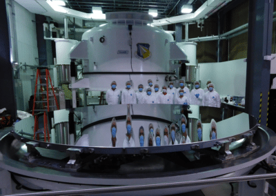 scientists stand behind the Inouye Solar Telescope's newly coated primary mirror.