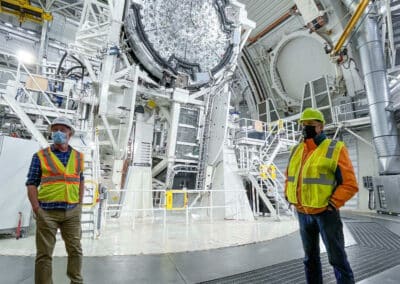 Thomas Rimmele, Inouye Solar Telescope Associate Director (center), and Matt Mountain, President of the Association of Universities for Research in Astronomy (right), stand in front the Inouye Solar Telescope with the back of the 13-ft primary mirror on show.