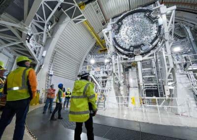 Members of the Inouye Solar Telescope team stand before the telescope mount.