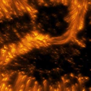 A detailed example of a light bridge crossing a sunspot’s umbra. In this picture, the presence of convection cells surrounding the sunspot is also evident. Hot solar material (plasma) rises in the bright centers of these surrounding “cells,” cools off, and then sinks below the surface in dark lanes in a process known as convection. The detailed image shows complex light bridge and convection cell structures on the Sun's surface or photosphere. Light bridge: A bright solar feature that spans across an umbra from one penumbra to the other. It is a complex structure, taking different forms and phases, and is believed to be the signature of the start of a decaying sunspot. Umbra: Dark, central region of a sunspot where the magnetic field is strongest. Image Title: Properties of Convection Cells and Light Bridge Seen Around a Sunspot PID: PID_1_29 Large Field of View: 30,720km x 30,720km Image Credit: NSF/AURA/NSO Image Processing: Friedrich Wöger(NSO), Catherine Fischer (NSO) Science Credit: Philip Lindner at Leibniz-Institut für Sonnenphysik (KIS)