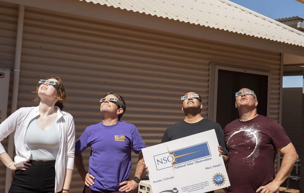 NSO team at the eclipse site, gazing up to the Sun using safety-certified eclipse glasses. Left to right: Sarah Bruce (CU Boulder), Kevin Reardon (NSO), Sanjay Gosain (NSO), and John Williams (NSO). Credit: John Williams/NSO/AURA/NSF